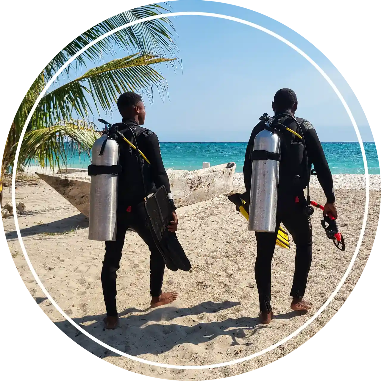 Fun Divers Zanzibar scuba diving team walking on the white sand beach of Pemba Island.